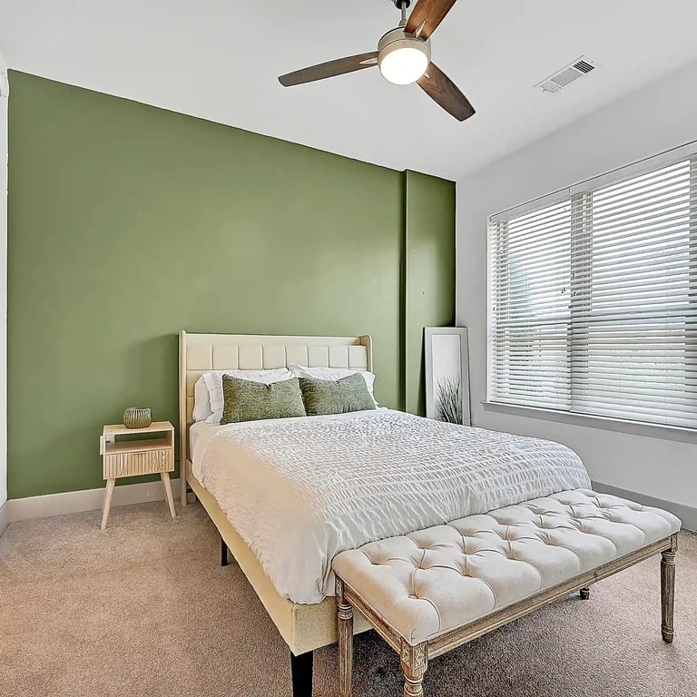 Cozy Philadelphia bedroom with soft lighting, neutral decor, and a bold green accent wall behind the bed