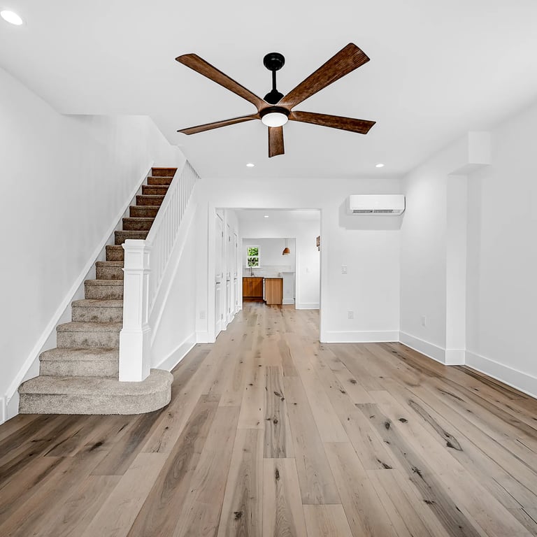 Bright and modern living room with hardwood floors and ceiling fan in a renovated Philadelphia home