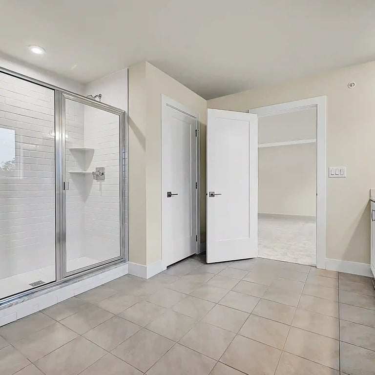 Spacious modern bathroom in Philadelphia featuring a glass shower, double vanity, and tile flooring—perfect for listings.