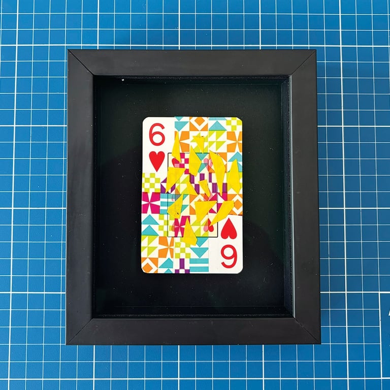 washi tape e fita isolante amarela sobre seis de copas, emoldurado em preto.