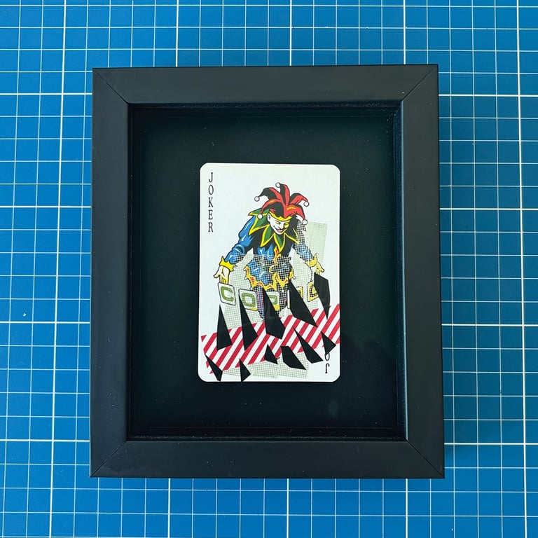 washi tape e fita isolante preta sobre coringa, emoldurado em preto.