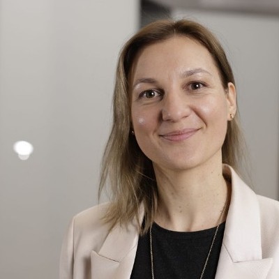 a woman in a white jacket and black shirt