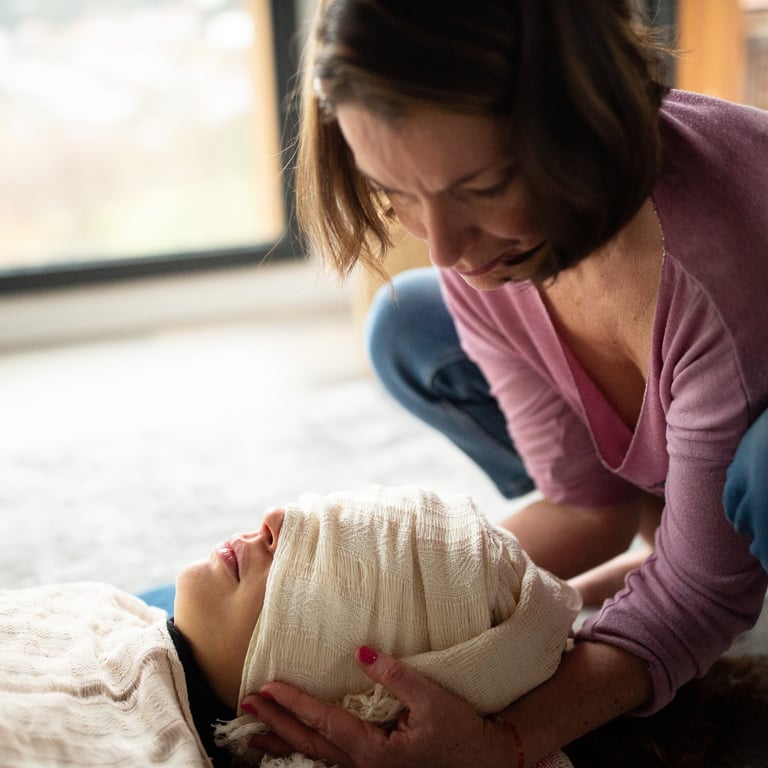 Femme tenant la tête d'une femme dans ses mains avec un rebozo- photo @Marie Pierson