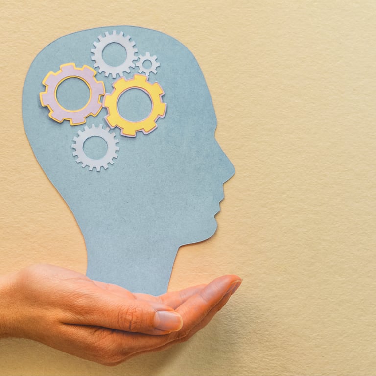 Nell'immagine si vede una mano che sostiene la sagoma di una testa, con degli ingranaggi lavoranti