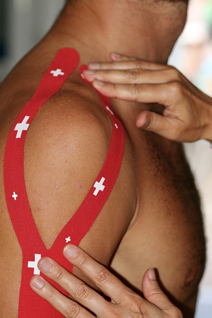 Sports Therapist applying tape to a client's shoulder