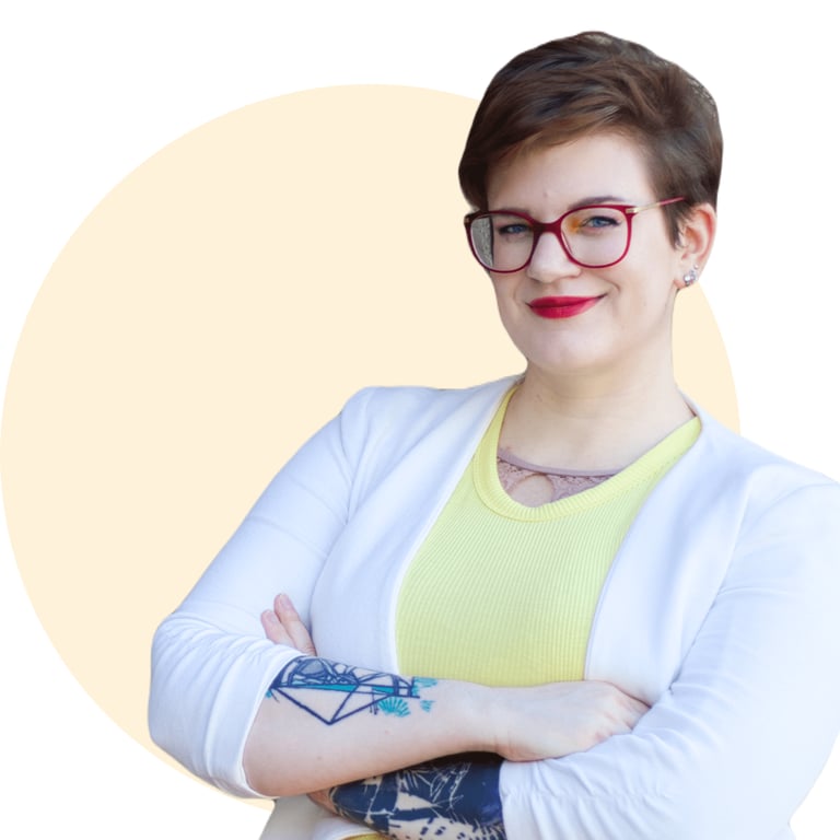 Swana Schuchmann, with a tattoo on her arm and a yellow shirt, smiling