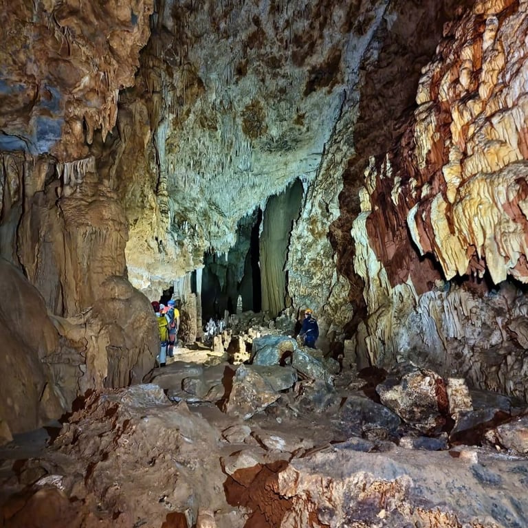Persona explorando el interior de la Cueva la Tinaja, rodeada de formaciones rocosas impresionantes 