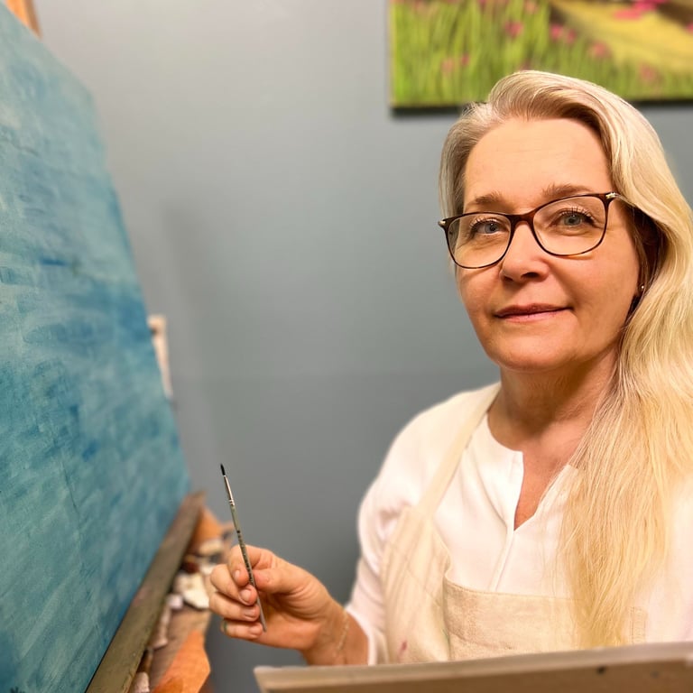 Else Norking, artista plástica, segura pincel enquanto trabalha em tela azul em seu ateliê.