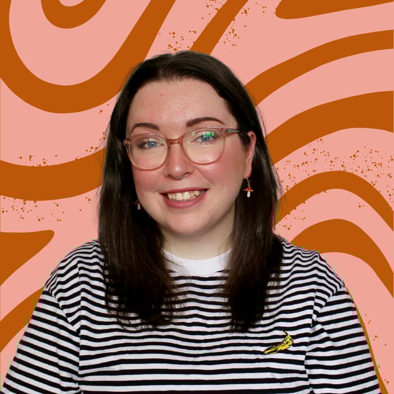 A women (Erin, owner of EB Socials) with glasses, brown hair and a blank and white striped top, smiling at the camera