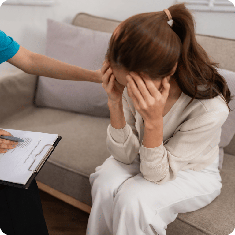 a woman in a white dress sitting on a couch