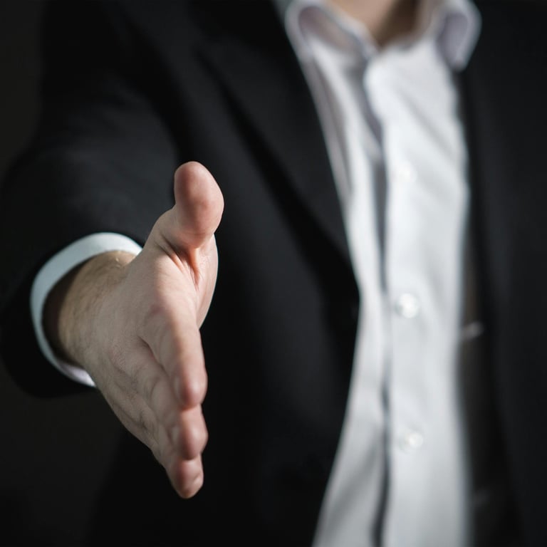 a man in a suit and tie is holding a hand out to a hand