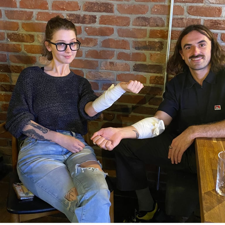2 people both with bandages on their forearms, displaying what they have been learning
