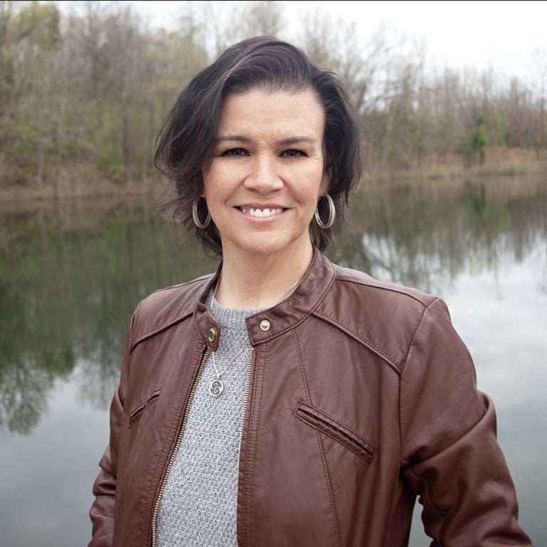 Amy Hale, paranormal romance author, standing outdoors near a lake