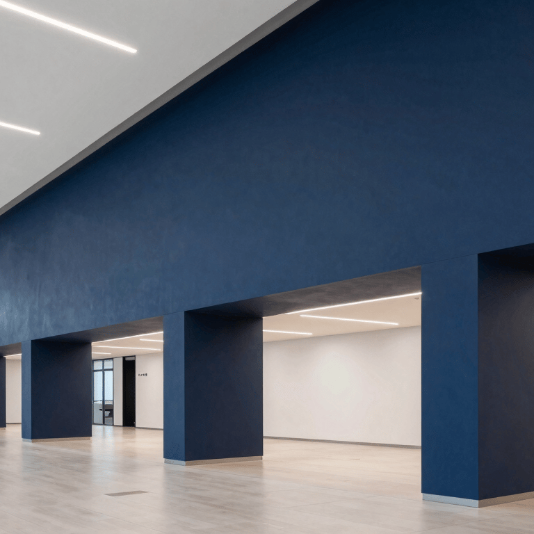 A minimalist architectural detail of a modern building with clean off-white lines against a soft silver blue sky.