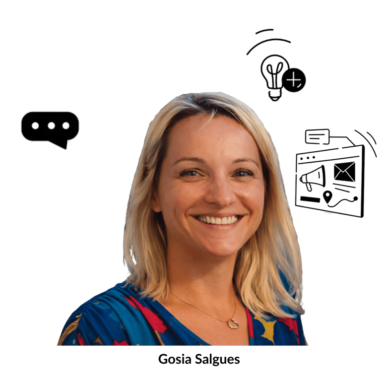 Smiling Gosia Salgues wearing a blue patterned shirt and heart necklace on a black background.
