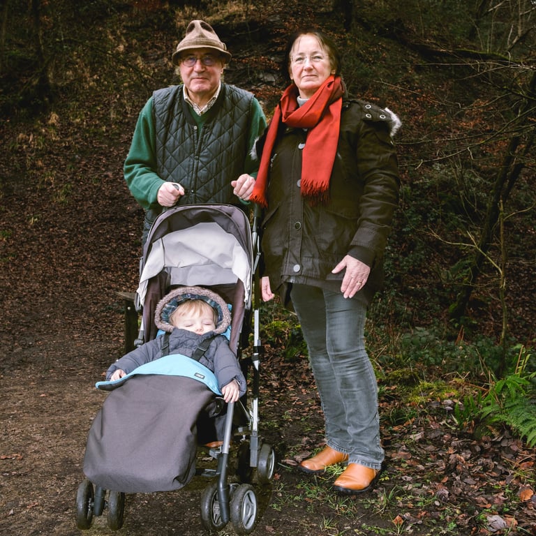 Couple pushing grandchild in pram