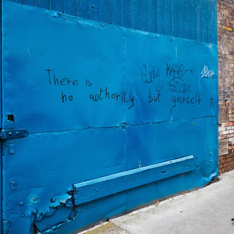Man walking past blue door with graffiti reading there is no authority