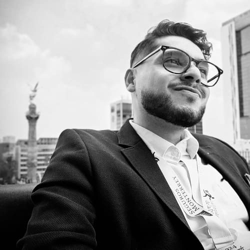 Alán Ángeles asesor patrimonial y de seguros con el monumento del Ángel de la Independencia detrás