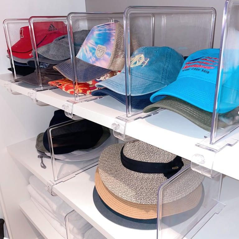 Hats in a organized closet on shelves separated by color and type, with shelf dividers.