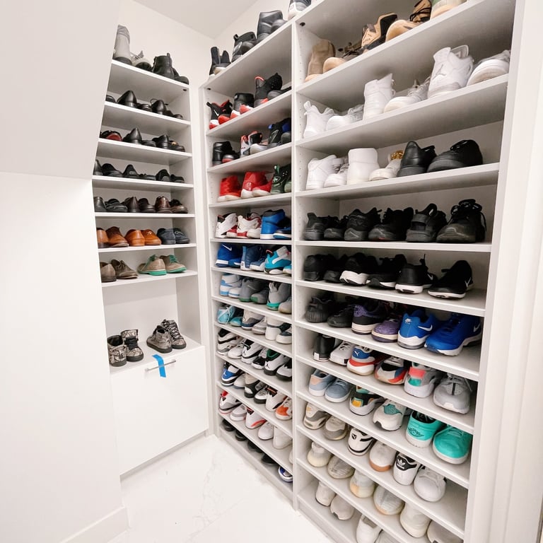 Closet with shoes displayed on shelves, organized by color and type, displayed to maximize space on the shelves.