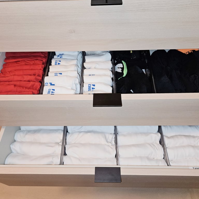 Closet drawer arranged and organized with underwear and socks by color and divided with drawer dividers so they are neat.