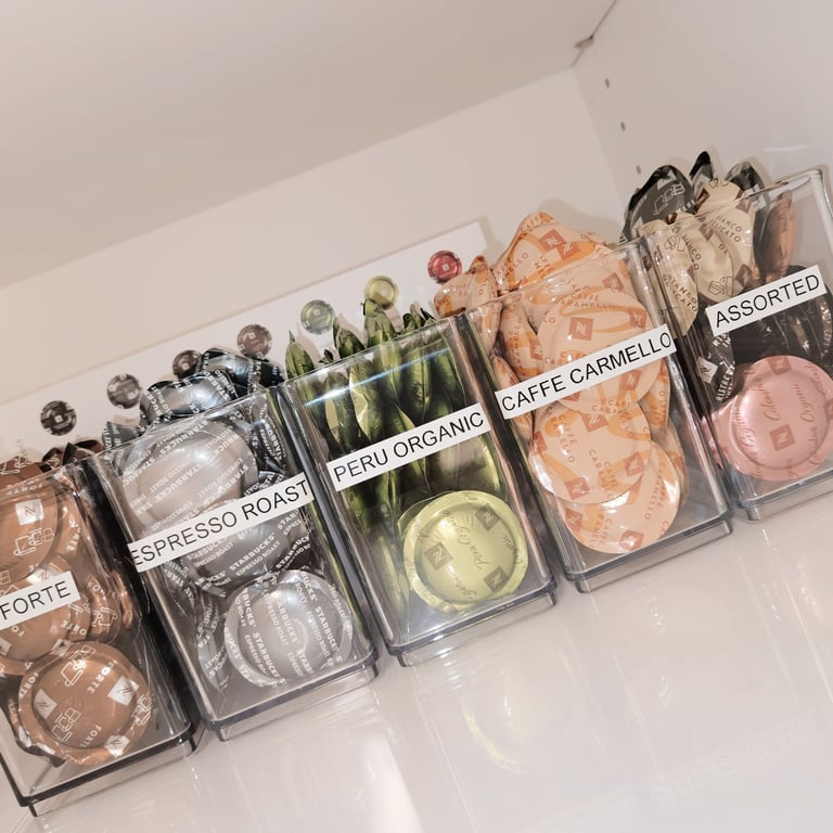 Coffee pods with labels and in containers in an organized office kitchen.