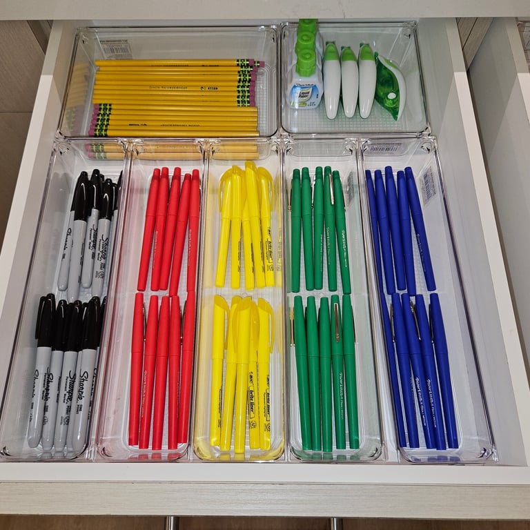 Office drawer with markers organized by color.