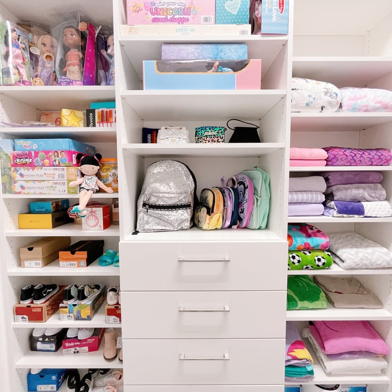Kids closet organized by color, neatly arranged on shelves, with shoes and clothing neat & tidy.