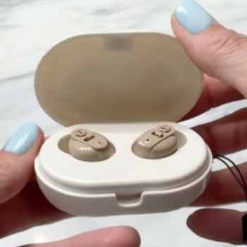 eine Person, die ein Paar Hörgeräte hält