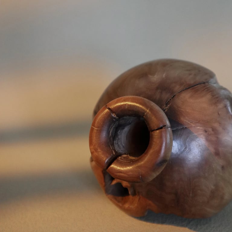 Close-up of a hand-carved decorative wooden vase with natural wood grain and rustic texture.