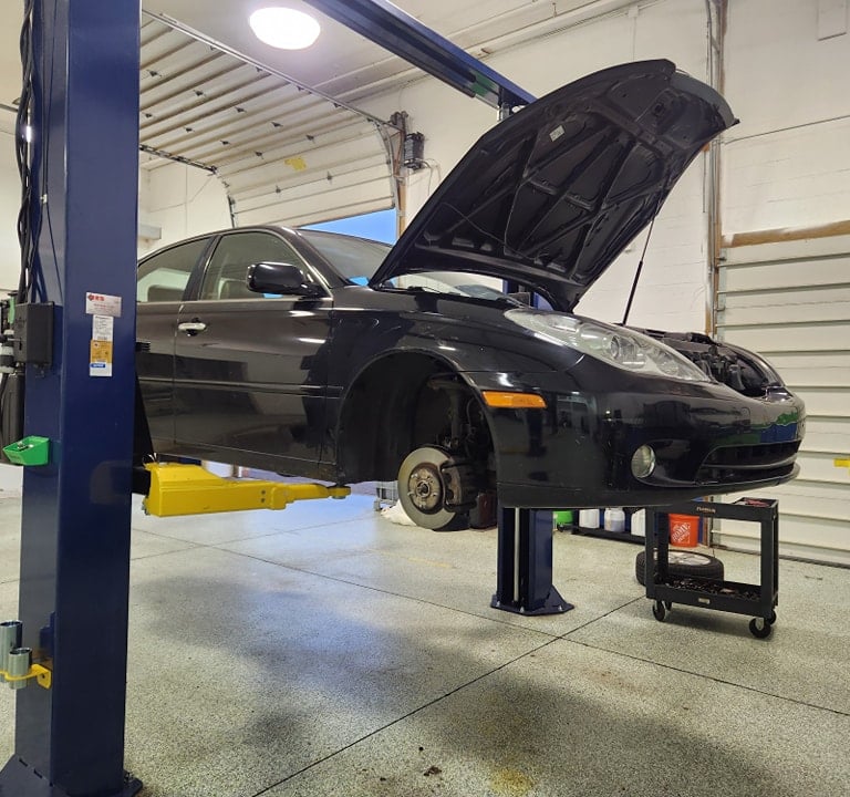 Car on a lift during full brake and tire service at Winston's Complete Auto Care in Cuyahoga Falls, Ohio