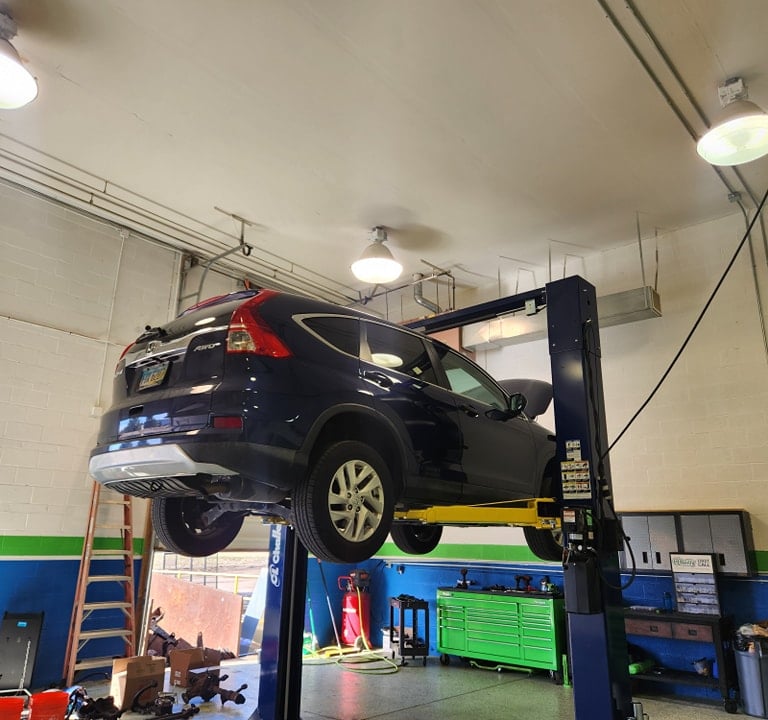 Car on a lift getting oil changed at Winston's Complete Auto Care in Cuyahoga Falls, Ohio