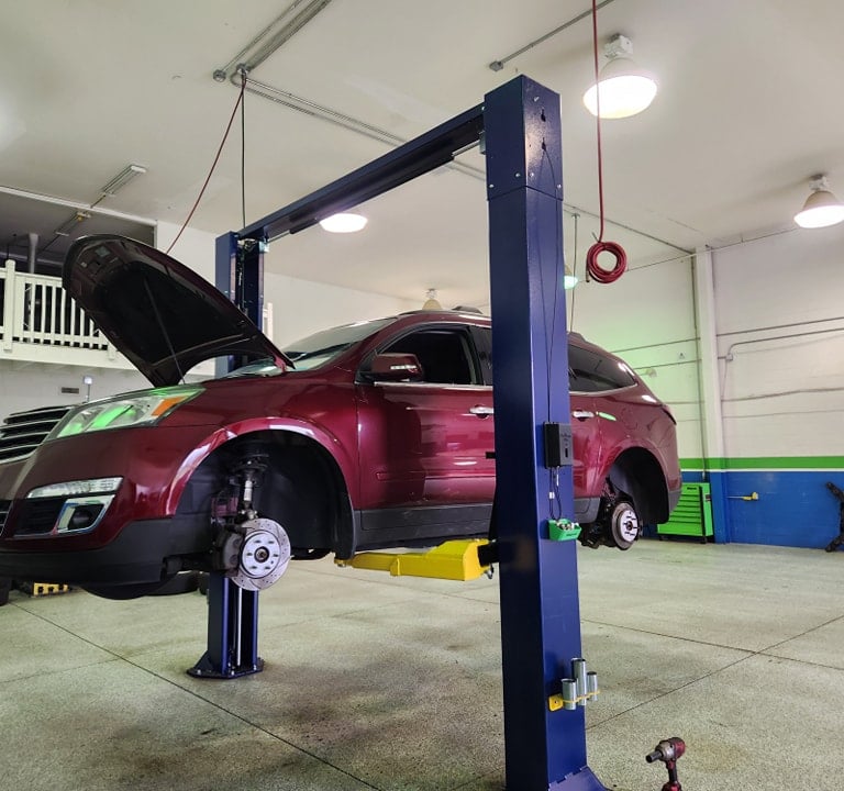 SUV on a lift getting tires replaced and oil change at Winston's Complete Auto Care in Cuyahoga Falls, Ohio