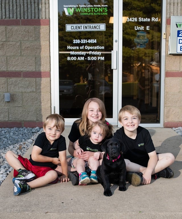 The Winston children sitting at the front entrance at Winston's Complete Auto Care in Cuyahoga Falls, Ohio