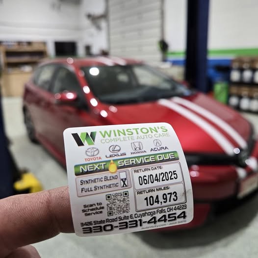 Car Service Sticker being placed on a car  at Winston's Complete Auto Care in Cuyahoga Falls, Ohio