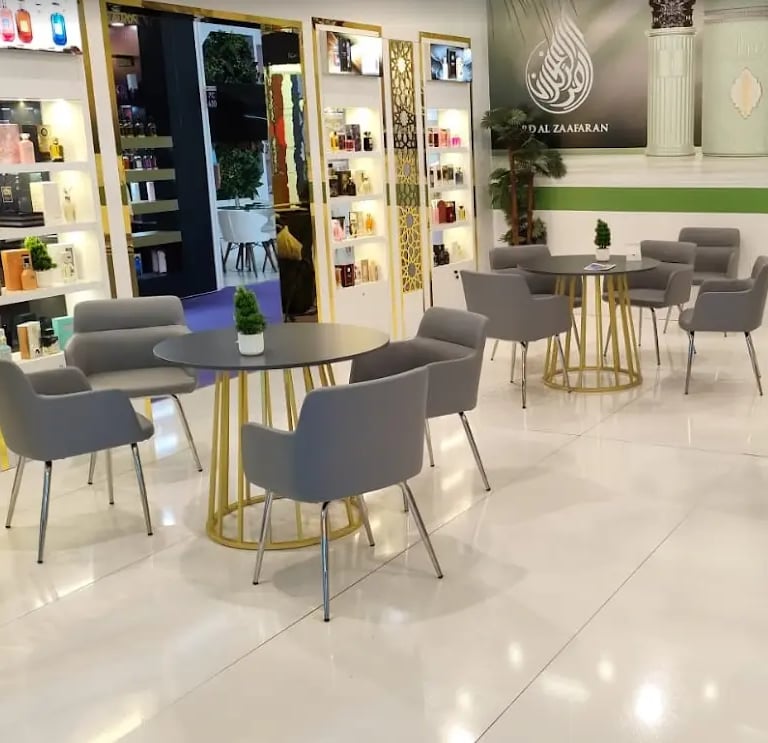 Premium lounge area with floral murals, grey velvet chairs, and gold tables designed as a luxury lifestyle space.