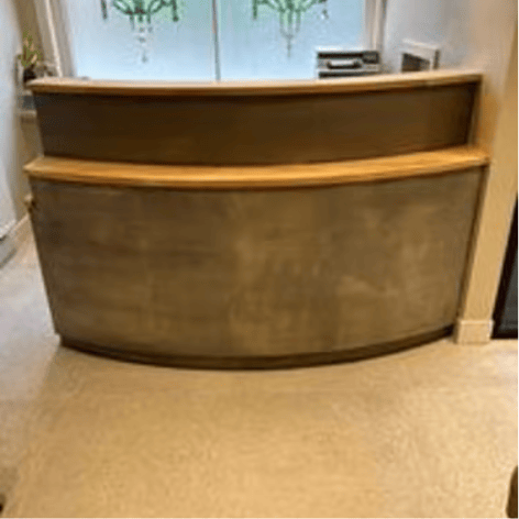 Modern reception desk in microcement in a minimalist office lobby.