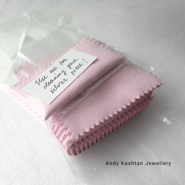 Pink jewelry cleaning cloths for silver pieces, individually packaged with a 'Use me for cleaning your silver piece!' note