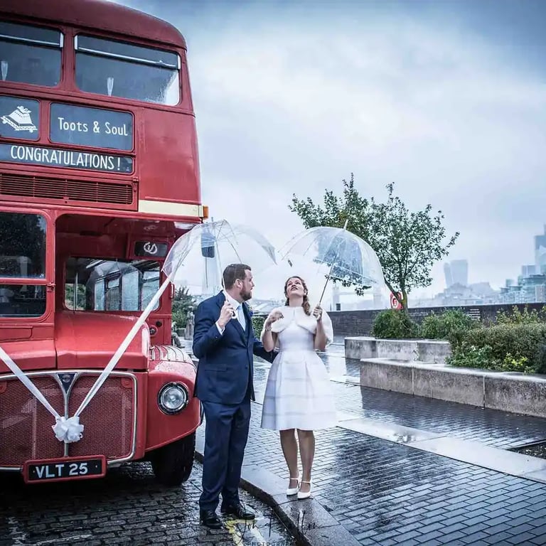 bride and Groom standing in front of a London red bus