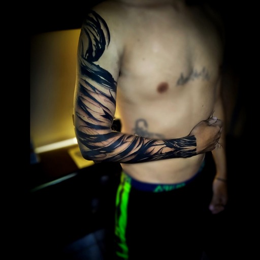 Tatuaje abstracto de estilo blackwork, con un diseño ornamental y detallado, que cubre el brazo.
