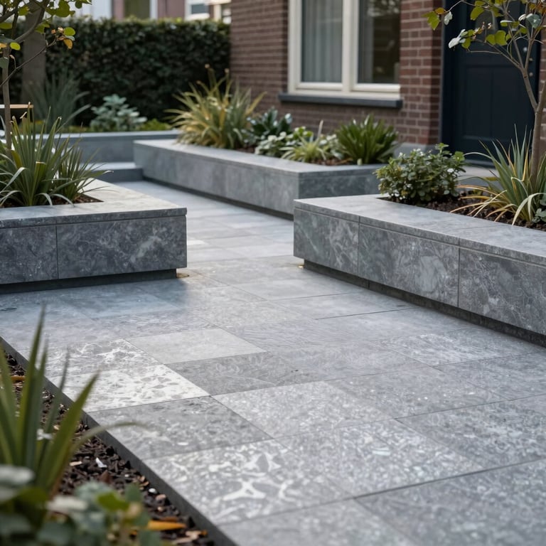 An elegant garden renovation in Utrecht featuring silver grey paving stones and minimalist landscaping.
