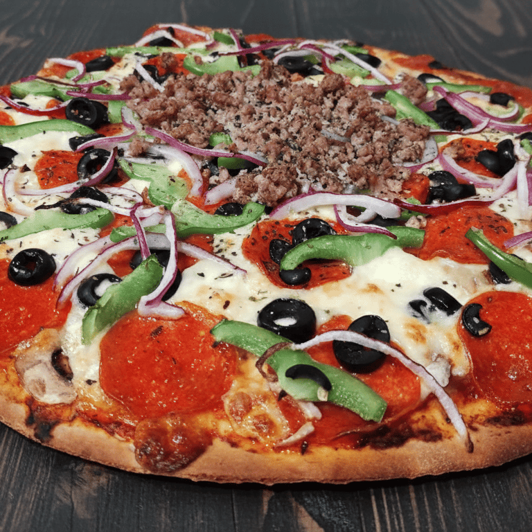 Pizza suprema fresca con pepperoni, pimientos verdes, cebollas y aceitunas negras sobre una mesa de 