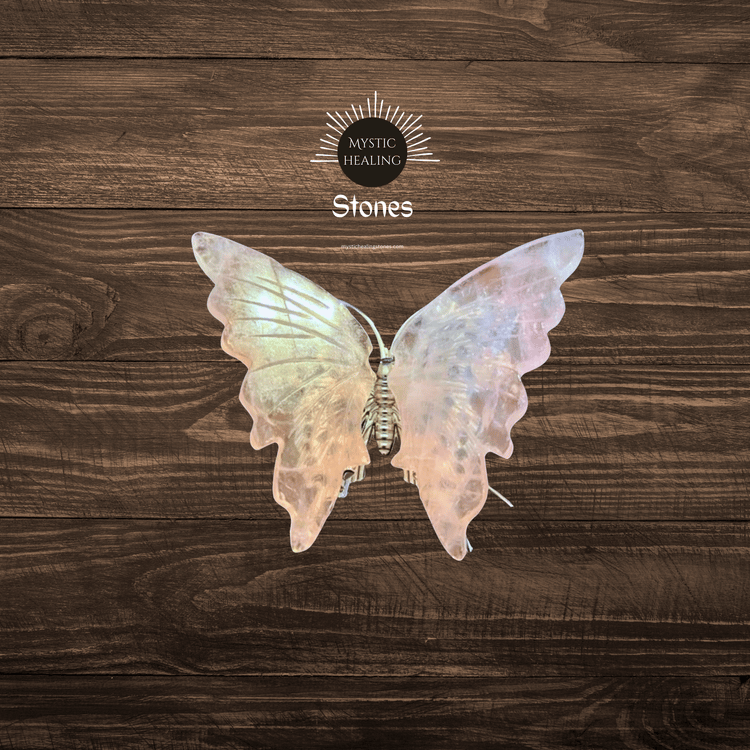 Iridescent rose quartz butterfly carving for healing crystals collection on a dark wood background.
