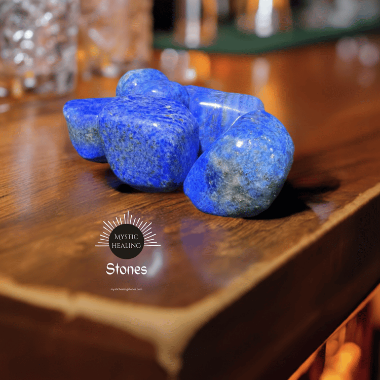 Polished blue lapis lazuli crystals and healing stones displayed on a wooden surface.
