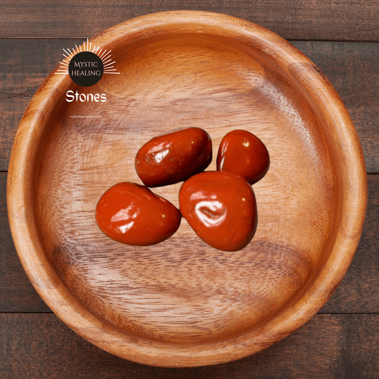 Polished red jasper stones for meditation and healing displayed in a rustic wooden bowl.