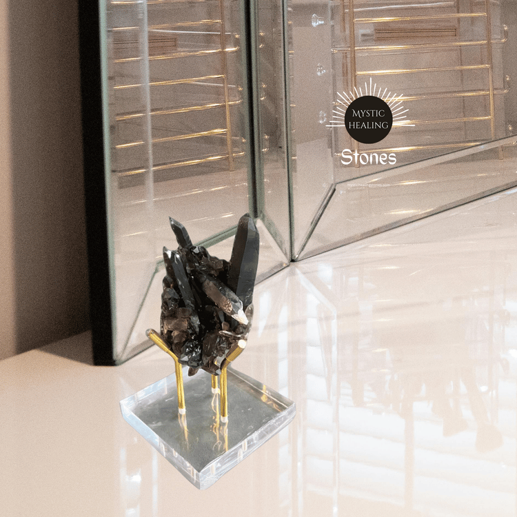 Smoky quartz crystal cluster on a gold metal stand for home decor and spiritual healing.