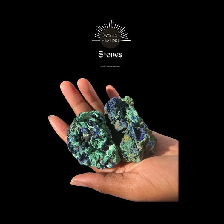 Raw azurite healing stones held in a person's hand against a black background.