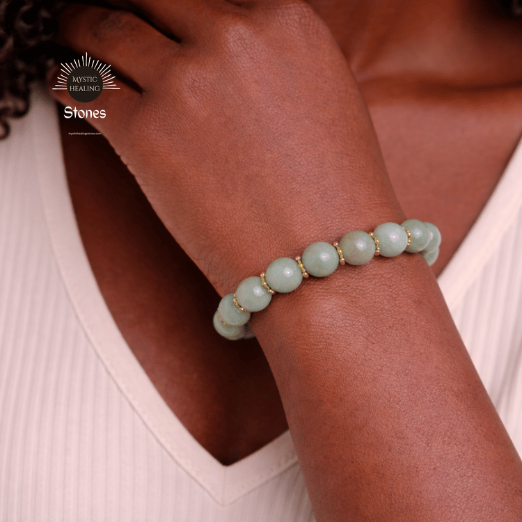 A person wearing a jade crystal bead bracelet with gold accents for healing.