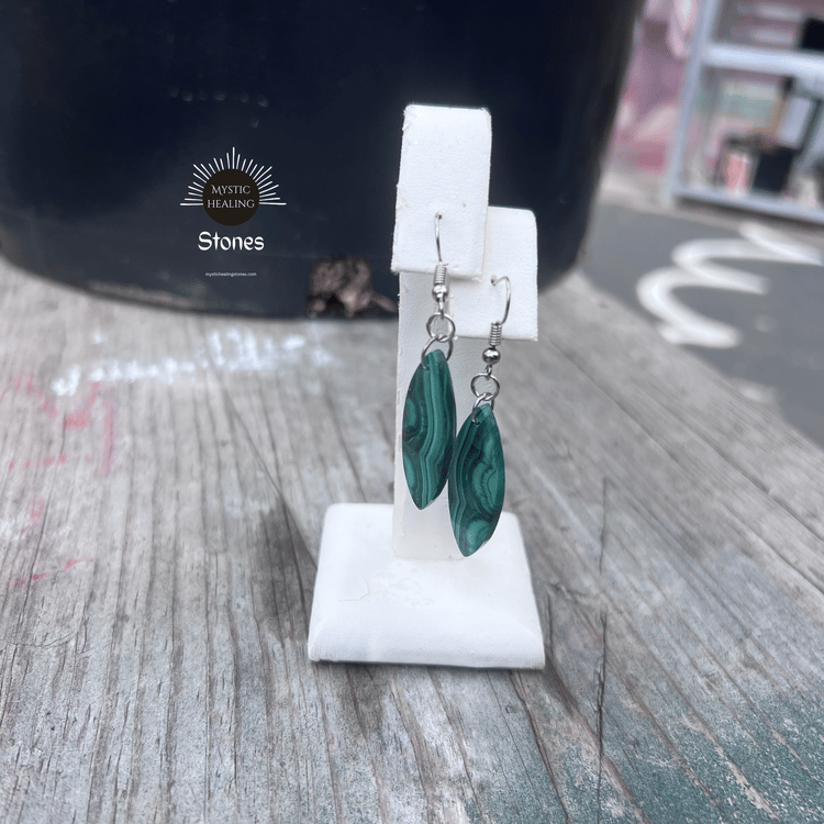 Green malachite crystal leaf earrings displayed on a white jewelry stand.