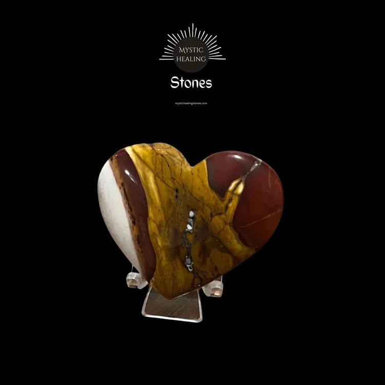 Polished heart-shaped Mookaite Jasper crystal featuring earthy red, yellow, and white patterns on a stand.